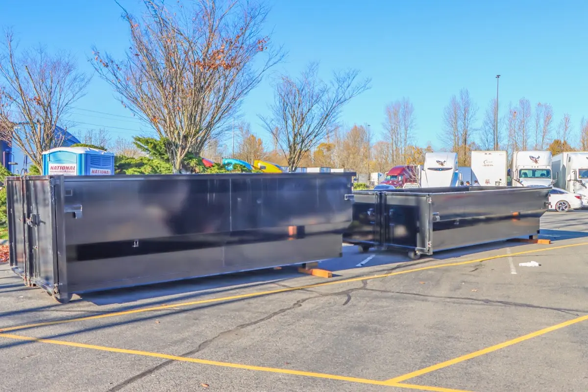 Professional dumpster rental service with roll-off container on residential driveway in Chesapeake Beach